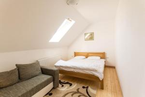 a small bedroom with a bed and a couch at Casa Vatra Sinteului - Cu sala de evenimente de capacitate mare - Se inchiriaza integral in Socet