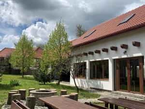 a building with a picnic table and benches in a yard at Casa Vatra Sinteului - Cu sala de evenimente de capacitate mare - Se inchiriaza integral in Socet