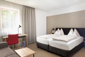 a hotel room with a bed and a desk and a couch at Gasthof Maxlhaid in Wels