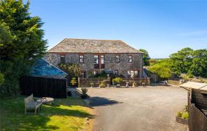 una vieja casa de piedra con un banco delante de ella en Fosfelle Cottages en Bideford