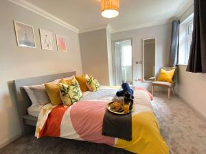 a bedroom with a large bed with colorful pillows at Beautiful Large 4 bedroom House - 5 Minute Walk to the Best Beach! - Great Location - Garden - Parking - Fast WiFi - Smart TV - Newly decorated - sleeps up to 10! Close to Bournemouth & Poole & Sandbanks in Bournemouth