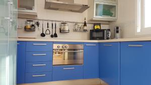 a kitchen with blue cabinets and a stove top oven at Casa Altos 76 in La Herradura