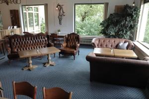 a waiting room with leather chairs and a table at Mellow Mountain Hostel in Ehrwald