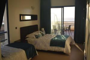 a bedroom with two beds and a view of the ocean at Auberge Oualidia Dream in Oualidia
