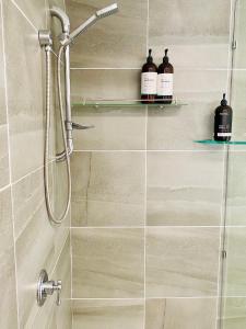 a shower with two bottles on a shelf in a bathroom at Eumundi Cottage in Town in Eumundi