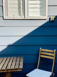 a wooden bench in front of a blue wall with a window at Eumundi Cottage in Town in Eumundi