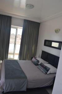 a bedroom with a bed with pillows and a window at Auberge Oualidia Dream in Oualidia