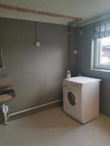 a laundry room with a washing machine and a window at Camp Sjusjøen in Mesnali