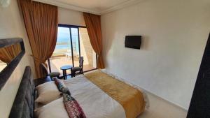 a bedroom with a bed with a view of the beach at Auberge Oualidia Dream in Oualidia