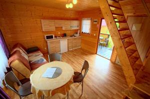 a room with a table and a kitchen in a cabin at Domki Letniskowe Orka in Jarosławiec