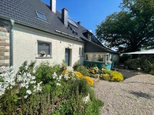 a garden in front of a house with flowers at Pension Kirschberg in Bretleben