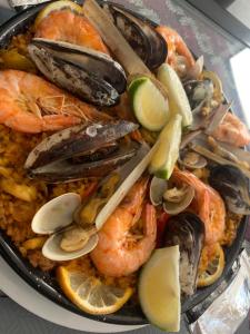 a pan filled with shrimp and rice with lemon slices at Auberge Oualidia Dream in Oualidia