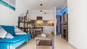 a living room with a blue couch and a kitchen at Meduse Holiday IUNQ5361 in Cala Gonone