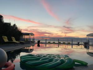 a swimming pool with a view of the ocean at sunset at Auberge Oualidia Dream in Oualidia