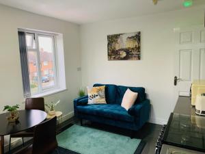 ein Wohnzimmer mit einem blauen Sofa und einem Tisch in der Unterkunft Cosy 2 bedrooms apartment in Birmingham in Birmingham