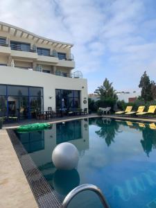 a swimming pool with a villa in the background at Auberge Oualidia Dream in Oualidia