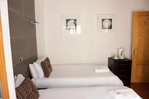 two beds in a room with white walls at Casa Don Juan in Benidorm