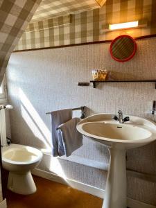 a bathroom with a sink and a toilet at Hôtel de famille L.F.M.A.L. in Giat