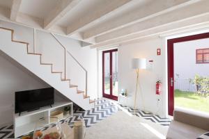 a white staircase in a living room with a tv at Loureiro Villas in Porto