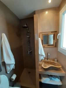 a bathroom with a sink and a shower at Plakes Luxury Apartments in Ermoupoli