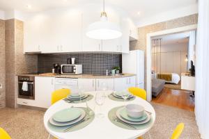 cocina y comedor con mesa blanca y sillas en D&S - Ribeira Premium Apartments, en Oporto