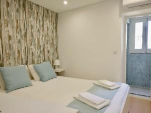 1 dormitorio con 1 cama blanca y 2 toallas en Porto Villa, en Oporto