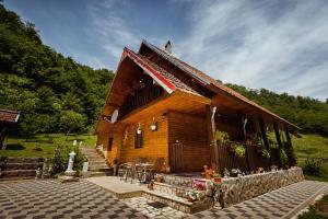 a wooden house with a staircase leading up to it at Cabana Daria in Ribicioara