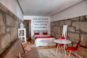 ein Schlafzimmer mit einem Bett und einer Steinmauer in der Unterkunft Try Oporto - Ribeira in Porto