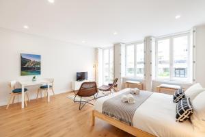 een witte slaapkamer met een bed, een bureau en stoelen bij Oporto Palace Apartments in Porto
