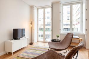 a living room with two chairs and a flat screen tv at Oporto Palace Apartments in Porto