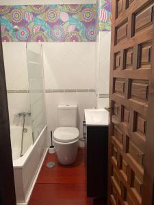 a bathroom with a toilet and a tub and a sink at Apartamento con zona chill-out y preciosas vistas in Granada