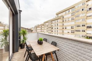 an apartment balcony with a wooden table and chairs at Oporto Palace Apartments in Porto