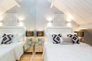 two beds in a room with white sheets and pillows at Loureiro Villas in Porto