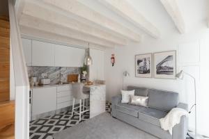 a living room with a couch and a kitchen at Loureiro Villas in Porto