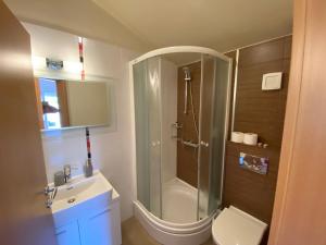 La salle de bains est pourvue d'une douche, de toilettes et d'un lavabo. dans l'établissement Apartments San Monte, à Podstrana