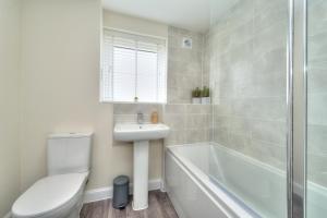 a bathroom with a toilet and a sink and a bath tub at Executive Fairfields Apartment by PAY AS U STAY in Milton Keynes
