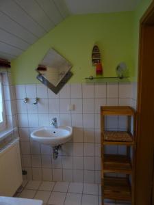 La salle de bains est pourvue d'un lavabo et d'un mur vert. dans l'établissement Ferienhaus Ferien am Waldrand, à Kurort Altenberg