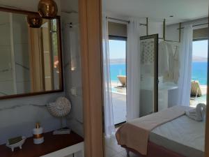 a bedroom with a bed and a view of the ocean at Luxury Villa Dioskouroi Heated eco pool & jacuzzi in Kalyves