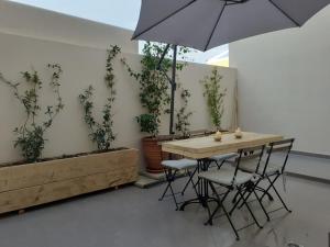 a table with chairs and an umbrella in a room at Plakes Luxury Apartments in Ermoupoli +15 photos
