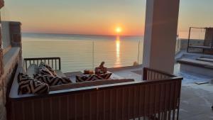 a living room with a view of the ocean at sunset at Luxury Villa Dioskouroi eco pool & jacuzzi Kalyves in Kalyves