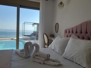 two swans made out of towels sitting on a bed at Luxury Villa Dioskouroi Heated eco pool & jacuzzi in Kalyves +56 photos