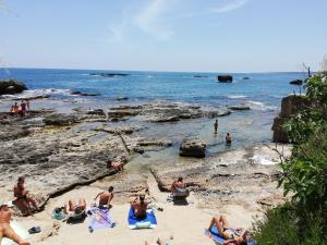 un grupo de personas sentadas en la arena en la playa en Casa Bianca, en Siracusa