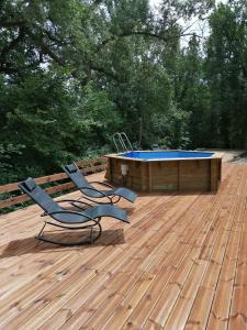 艾格倫的住宿－L'Oustaou d'Aiglun，木甲板上设有两把椅子和一个游泳池