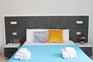 een slaapkamer met een groot bed en 2 handdoeken bij Thalasso Rooms B&B in Cirella