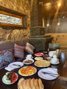 a table with many plates of food on it at Guest House Nikala in Mestia