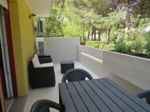 patio con mesa de madera y sillas en el balcón en APPARTAMENTO DANTE, en Cervia