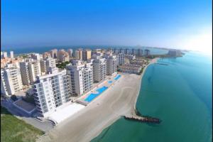 - une vue aérienne sur une plage avec des bâtiments et l'océan dans l'établissement La Manga Beach Club- LMHA 07, à La Manga del Mar Meno