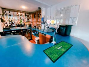 a bar with a blue counter top and a bar at Redwings Lodge Sawtry Huntingdon in Sawtry