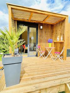 a wooden deck with chairs and a table at Cabane de Rafael in Vittel
