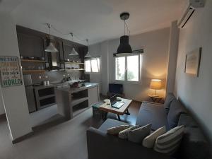 a living room with a couch and a kitchen at Plakes Luxury Apartments in Ermoupoli